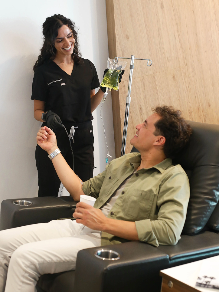 Professional nurse administering IV therapy to a relaxed client